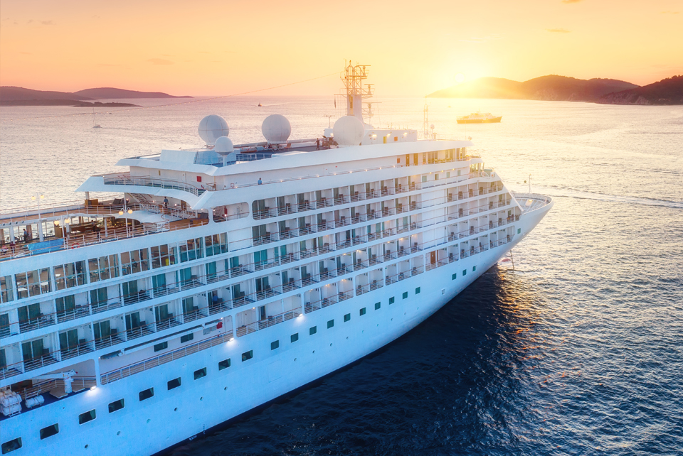 Cruise line on water with sunset in background
