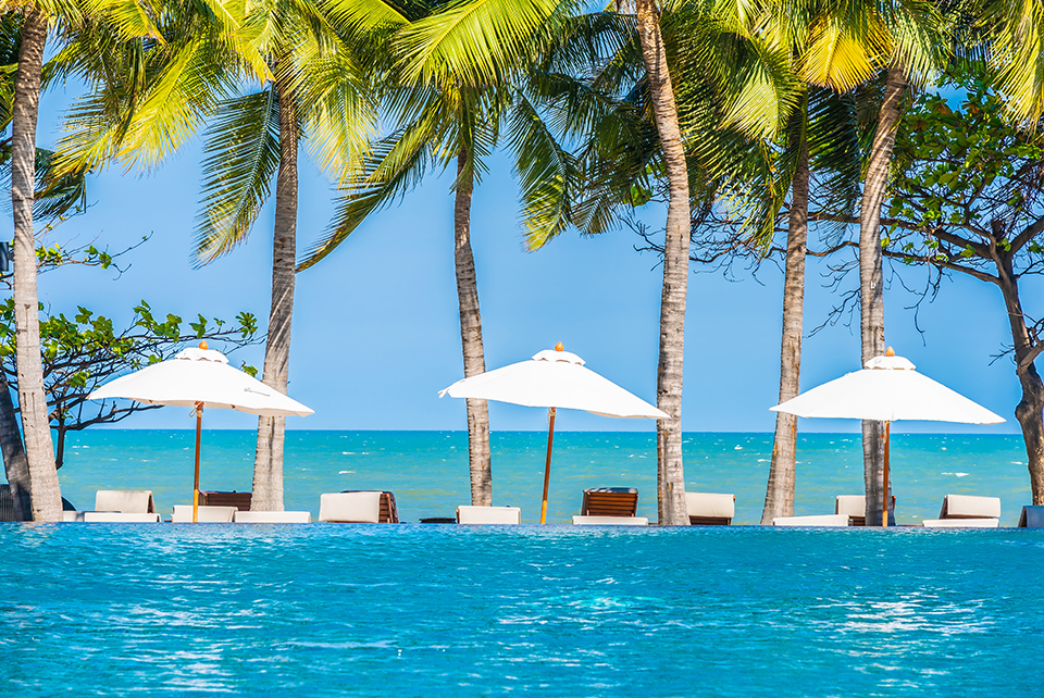 Pool umbrellas against pool and ocean